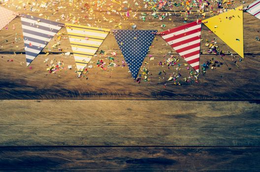The colorful flag line decorating the banquet has wooden floor as background.