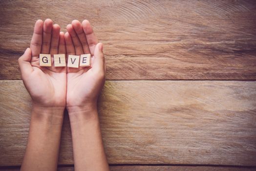 The word "GIVE" in hands in cupped shape. Concepts of sharing, giving, 