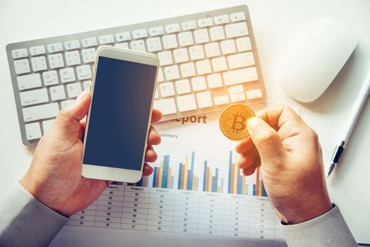 Man holding Bitcoin and background with Smart Phones, Laptops and Business Graphs - Concepts for Starting a Business and Investing