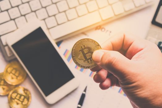 Man holding Bitcoin and background with Smart Phones, Laptops and Business Graphs - Concepts for Starting a Business and Investing
