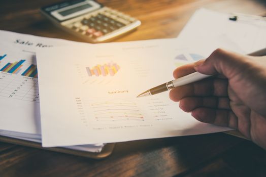 Business people are working on accounts in business analysis with graphs and documentation.