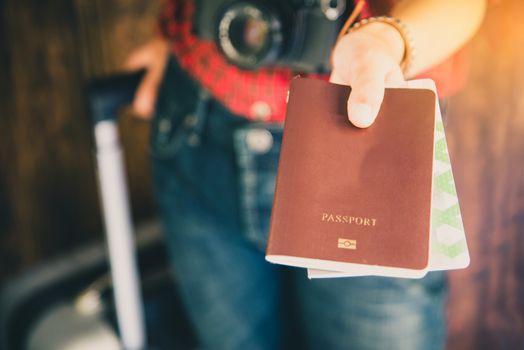 Passengers hold passports and travel luggage tickets to show to inspectors.
