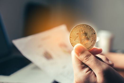 Hand of a businessman holding a gold coin 