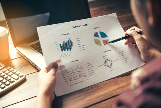 Business people are working on accounts in business analysis with graphs and documentation laptop in 