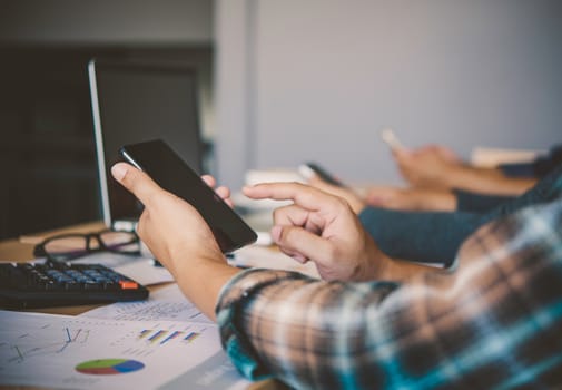 Businessman group uses a cell phone to send information to a meeting.