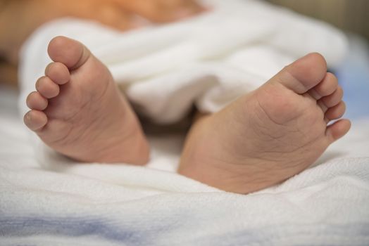 Baby's feet are on the couch.