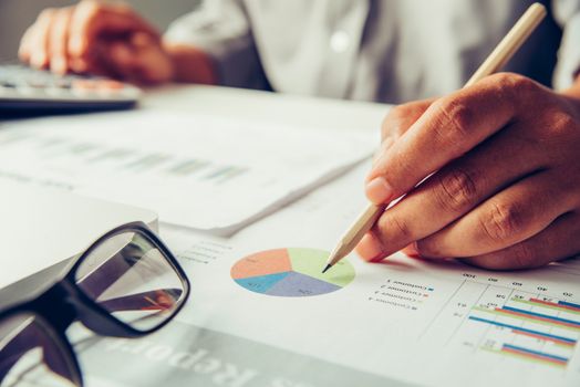 Business people are working on accounts in business analysis with graphs and documentation.
