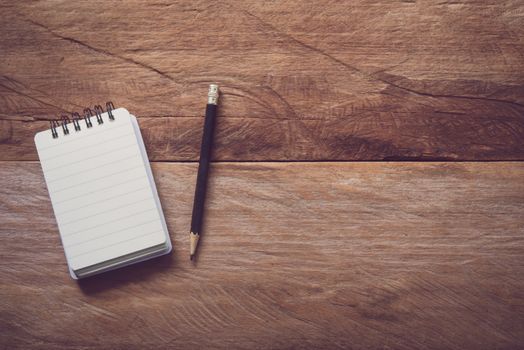 blank notebook with pencil on wooden table 
