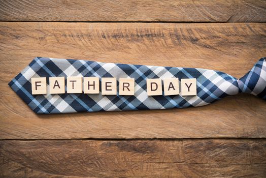 Necktie and the word "Father Day" lay on the wooden floor. gift for dad