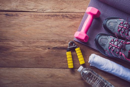 fitness concept with Exercise Equipment on wooden background.