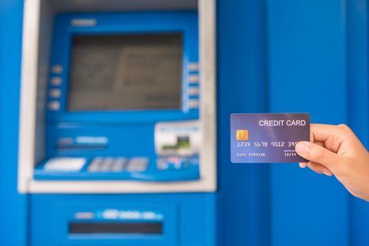 Hand inserting with a credit card into bank machine . Man using an atm machine with  credit card to withdraw money