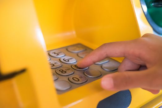 Hand inserting with a credit card into bank machine . Man using an atm machine with  credit card to withdraw money