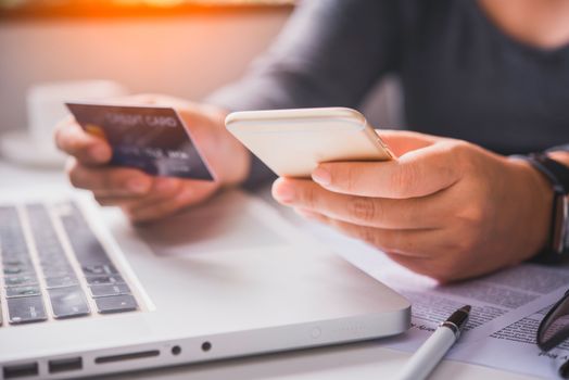 Online payment, hands holding a credit card and using smart phone for online shopping,
Online financial transactions