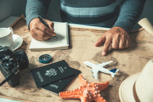 Travelers are planning a trip by searching the route on the map and preparing the necessary travel 