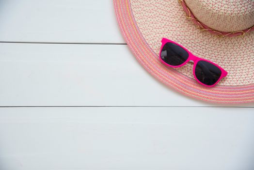 Hat and red sunglasses fashion on the pink wood for women