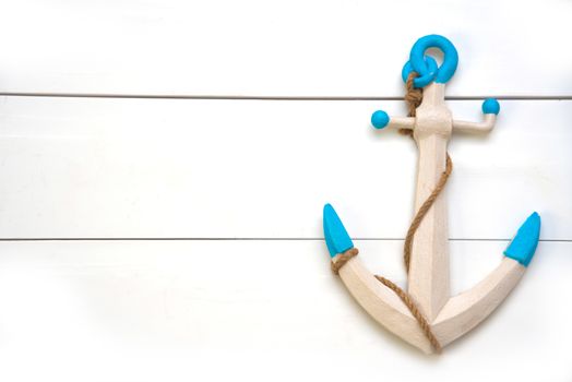 The anchor is placed on a white wooden floor.