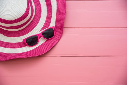 Hat and red sunglasses fashion on the pink wood for women