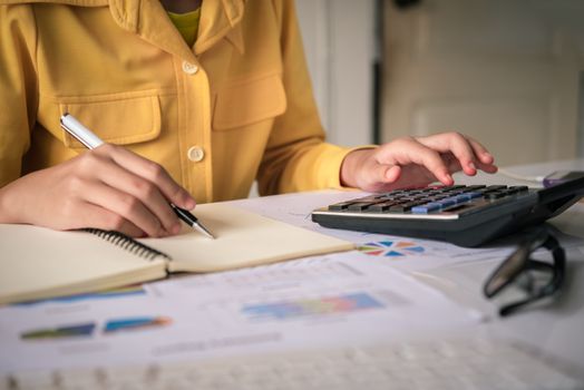 Businesswoman a working on accounts in business analysis with graphs and documentation.