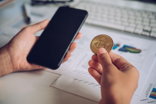 Man holding Bitcoin and background with Smart Phones, Laptops and Business Graphs - Concepts for Starting a Business and Investing