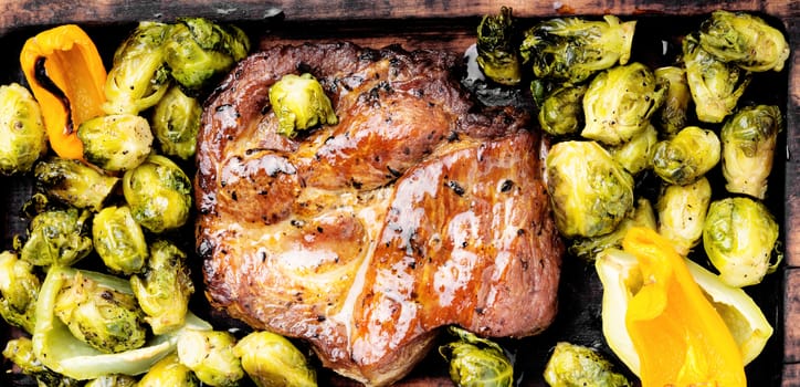 Juicy steak medium rare beef on wooden kitchen board.Grilled meat with Brussels sprouts.BBQ