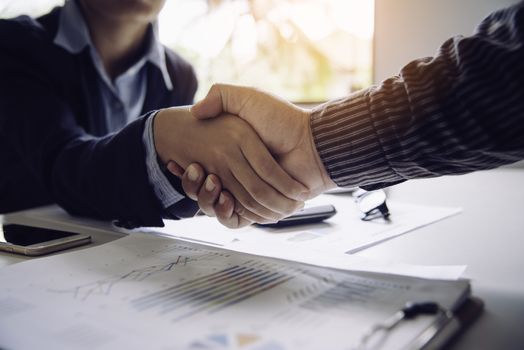 Businessmen shake hands with successful partners and congratulate