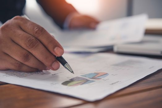 Business people are working on accounts in business analysis with graphs and documentation.