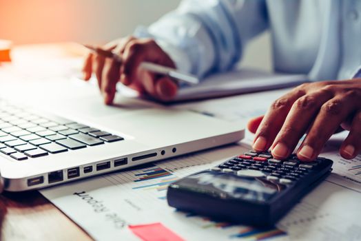 people are working with a calculator and laptop. in office business concept