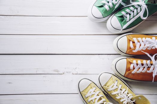 Sports shoes, work shoes, put on a white wooden floor - a living concept.