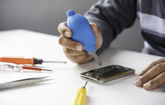 Repairman disassembling Repairman disassembling smartphone with screwdriver.