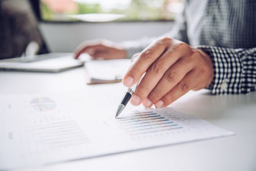 Business people are working on accounts in business analysis with graphs and documentation.
