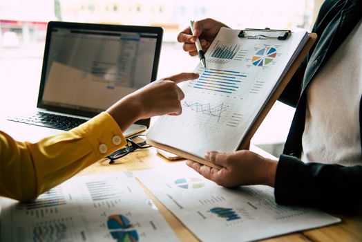 Business team is working on accounting documents and team work together to present the work and help solve the problem.