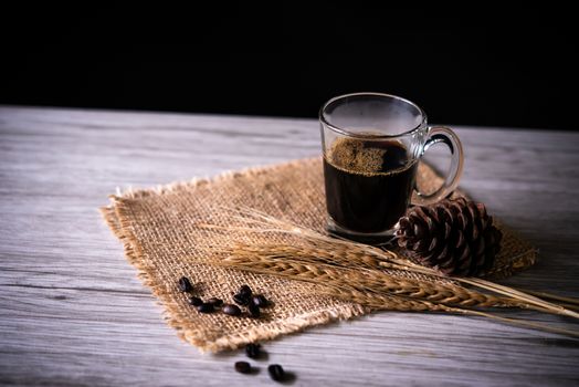Black coffee in glass is placed on wooden floor - concept still life