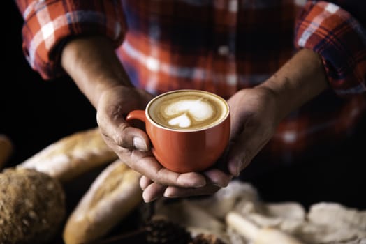 Barista's hands are delivering coffee to customers.