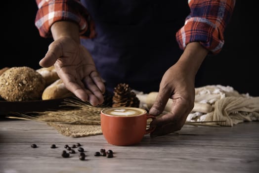 Barista's hands are delivering coffee to customers.