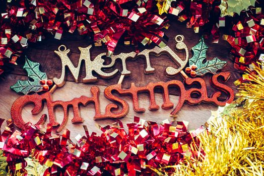 Christmas decorations and "Merry christmas" greetings on a wood background.