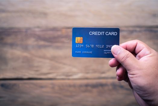 Hand holding a credit card make purchases online and conduct financial transactions.