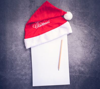 Santa hat and paper, pencil writing concept