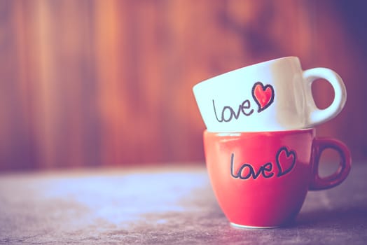 Coffee cup with "love" stacked on the floor.