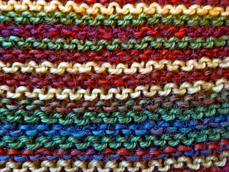 Knitted multicolored fabric texture. Background image. Hobbies, leisure, crafts. Horizontal arrangement of the pattern