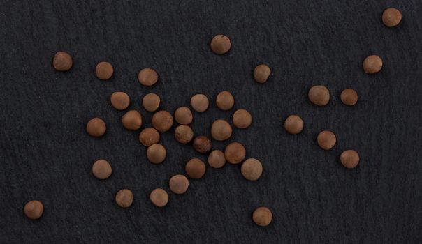 Lentils grain on black background, top view