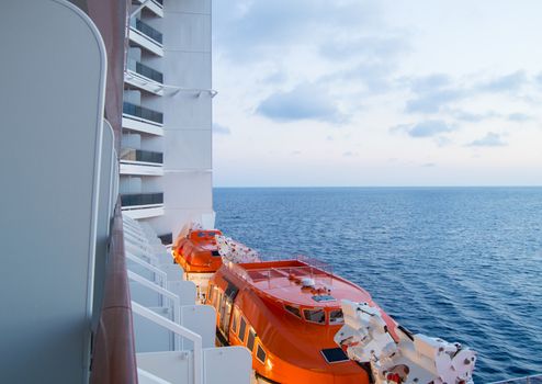 Sunset on the Mediterranean sea, a beautiful view from the cruise ship, visible lifeboats.