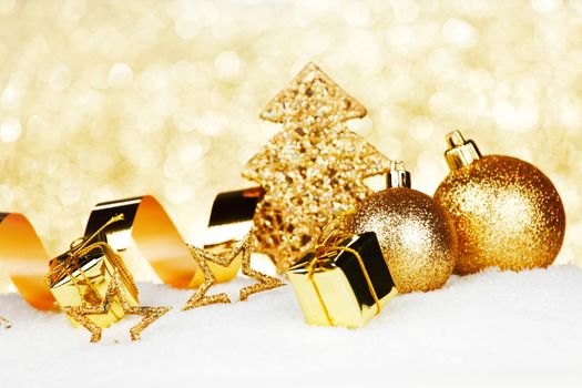 Golden Christmas decorations on snow close-up