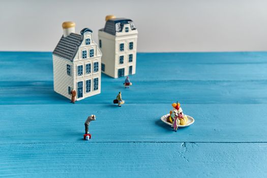 Close up lover traveler is taking photo by her boyfriend at ice cream monument have blur people and Europe style house as background on blue sea plank wood with copy space. Travel concept photography.