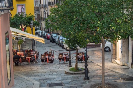 Traditional outdoor cafe on a narrow cobbled street after rain in Cagliari, Italy, 09 October 2018, SELECTIVE FOCUS.