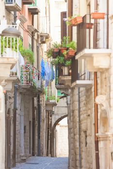 Molfetta, Apulia, Italy - Old balconies and a historical archway in an alleyway of Molfetta