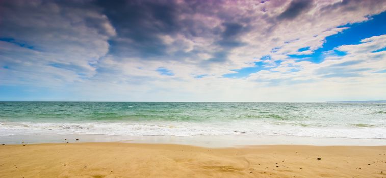 A wide angle landscape shot of beach in the sun