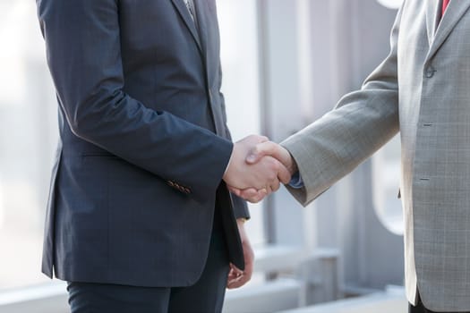 Business people in formal wear shaking hands close up view