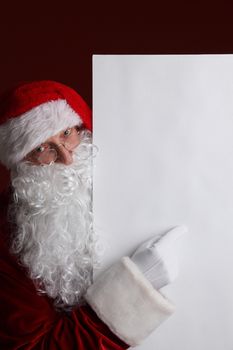 Santa Claus holding white paper billboard with copy space for text