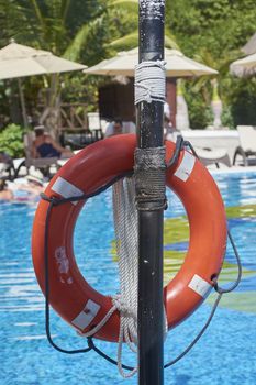 Orange life buoy attached to a pole: safety object in case of need.