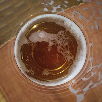 Glass of beer seen from above in which one sees the liquid inside in macro shot.